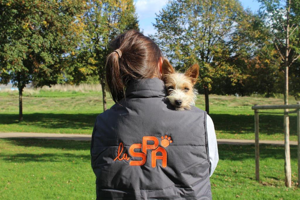 Bénévole d'un refuge de la SPA avec un chien dans les bras